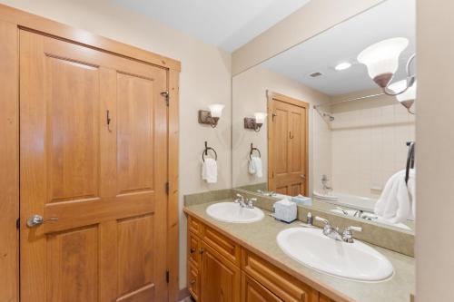 a bathroom with two sinks and a large mirror at Expedition Station 8576 by Summit County Mountain Retreats in Snake River Health Services Incorporated Heliport
