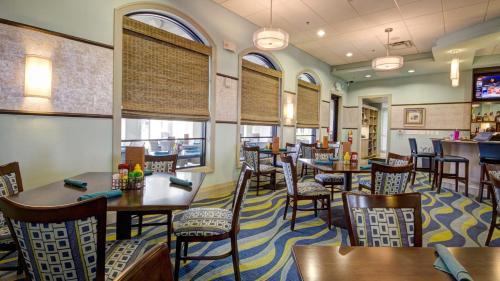 a dining room with tables and chairs in a restaurant at Lovely apartments 18 Minutes away from Disney! in Kissimmee