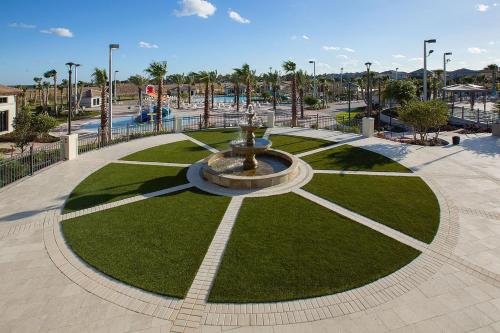 a fountain in a park with grass and palm trees at Lovely apartments 18 Minutes away from Disney! in Kissimmee