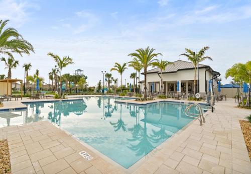 a pool at a resort with palm trees at Lovely apartments 18 Minutes away from Disney! in Kissimmee