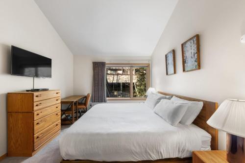 una camera con letto, TV e scrivania di Ski Run 412 by Summit County Mountain Retreats a Snake River Health Services Incorporated Heliport