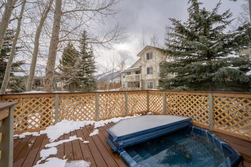 a hot tub on a wooden deck in the snow at Prospect Point Townhomes 202C by Summit County Mountain Retreats in Summit Medical Center Heliport