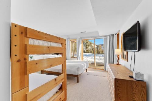 a bedroom with a bunk bed and a television at Quicksilver 1621 by Summit County Mountain Retreats in Keystone