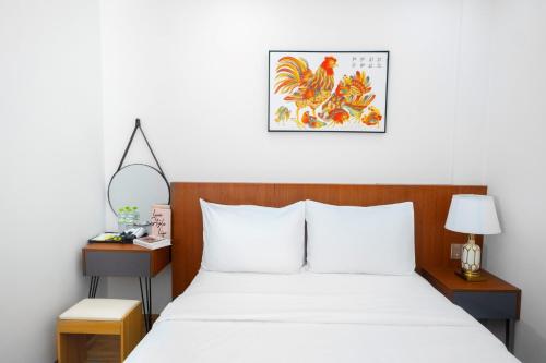 a bedroom with a white bed with two nightstands and a bed sidx sidx at Great Hotel Phú Quốc in Phu Quoc
