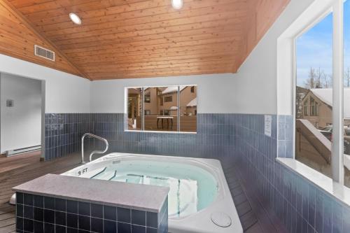 a hot tub in a room with a wooden ceiling at Quicksilver 1621 by Summit County Mountain Retreats in Keystone
