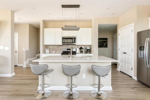 a kitchen with a counter and two stools at Luxury 2St Home, By Austin Airport, Gym, Pool in Austin