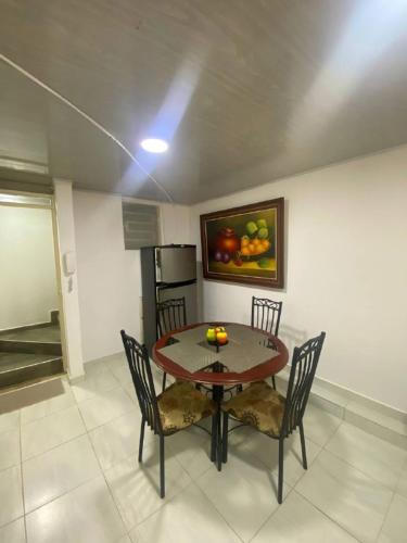 a dining room with a table and chairs with fruit on it at Amoblados Living in Estación El Salto