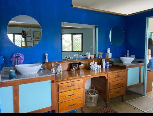 une salle de bain avec deux lavabos et un grand miroir dans l'établissement The Niu Haven - 5 Bdrm Home with Pool - A Kidsfirst Apartments Property, à Suva
