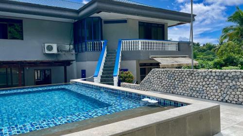 a house with a swimming pool in front of a house at Ngermid Oasis - Studio W/ Kitchenette & Pool View in Koror