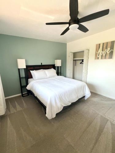 a bedroom with a large white bed with a ceiling fan at Park Home- Parkside Haven for Families & Pets in Pocatello