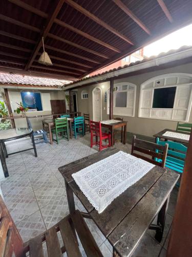 a patio with a wooden table and chairs and a table and tablesktop at Pousada Nativo in Morro de São Paulo