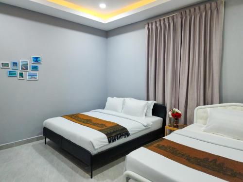 a hotel room with two beds and a window at BKK Concept Hotel in Phnom Penh
