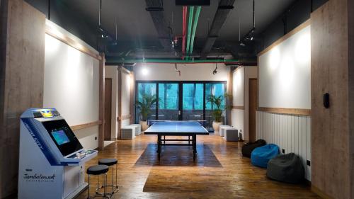 a room with a table and a video game at Jambuluwuk Bromo Poshtel in Pasuruan