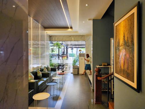 a woman walking down a hallway with a living room at BKK Concept Hotel in Phnom Penh