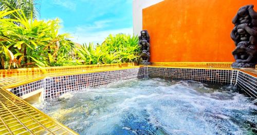 a jacuzzi tub in a backyard with a fountain at HIDELAND Luxury Pool Villa Pattaya Walking Street in Pattaya South