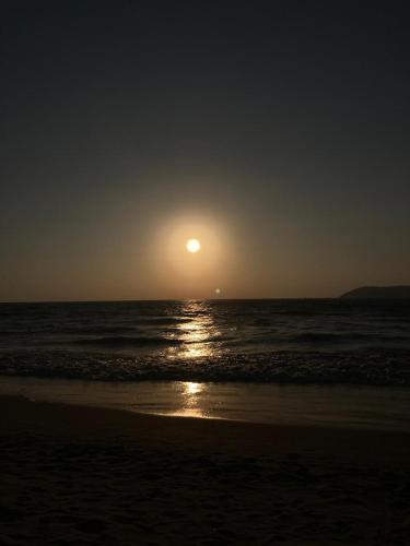 a sun setting over the ocean on a beach at Purnima Resort Neil Island in Neil Island