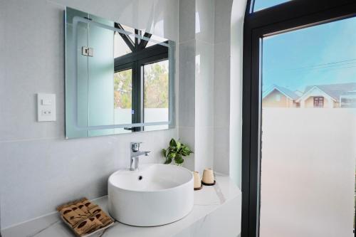 a bathroom with a white sink and a mirror at Lotus Hotel Đà Lạt in Da Lat