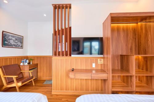 a hotel room with a desk and a tv at Lotus Hotel Đà Lạt in Da Lat