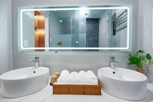a bathroom with two sinks and a mirror at Lotus Hotel Đà Lạt in Da Lat