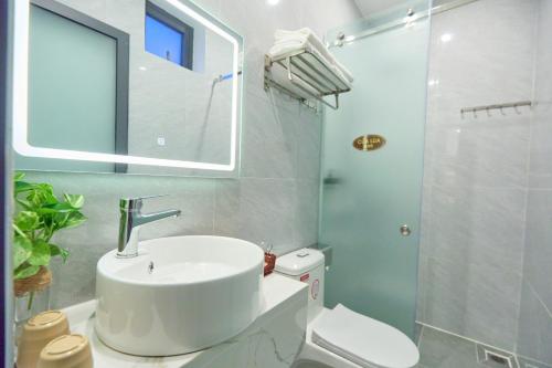 a bathroom with a sink and a toilet and a window at Lotus Hotel Đà Lạt in Da Lat