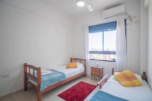 a bedroom with two beds and a window at Ubicación perfecta con vista al Puente, AC, WIFI in Vuelta del Paraguayo
