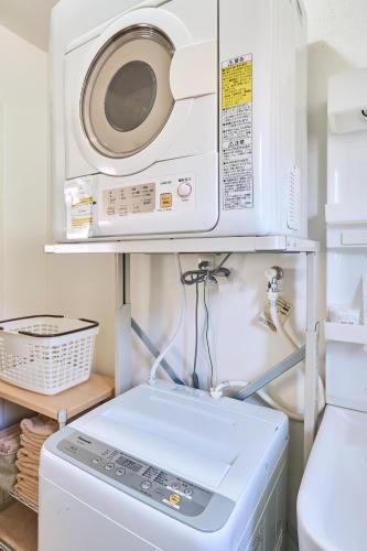 a microwave and a washer and dryer in a kitchen at KOSHIGOE seaside inn in Kamakura