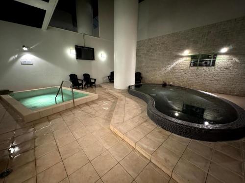 a large bathroom with a tub and a tv at Spa Resort LiVEMAX in Mooka