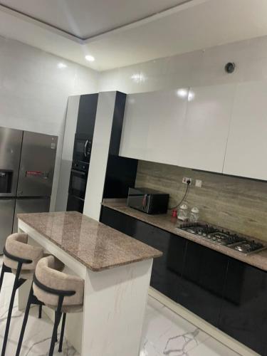 a kitchen with a counter and some stools in it at Luxury 5 bedroom standalone with PS5, WiFi, gym in Lekki