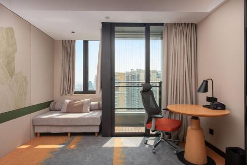 a room with a bed and a desk and a table at Mido International Hotel in Guangzhou
