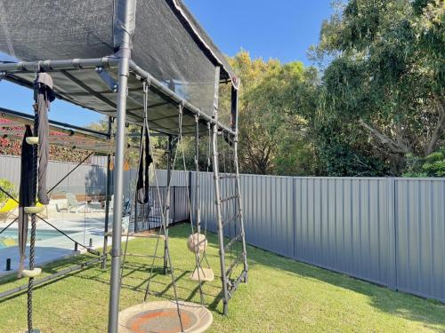 a batting cage in a backyard with a fence at The Mermaid's Retreat - Pool in Kiama! in Kiama