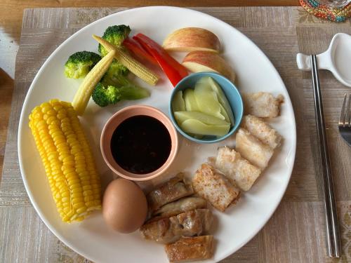 a plate of food with corn broccoli and other foods at 大方來富莊園民宿DF Life Lodge in Yongan