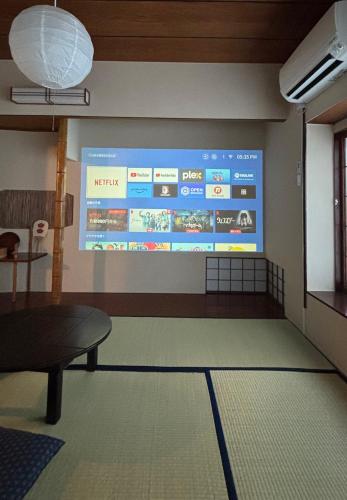 a projection screen on a wall in a room at 梅の宿Umenoya PC1 in Odawara