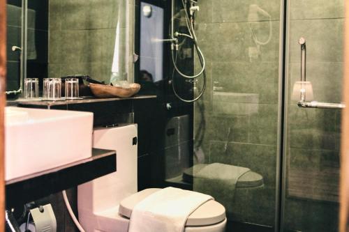 a bathroom with a shower and a toilet and a sink at Lavanya Boutique Hotel in Phnom Penh