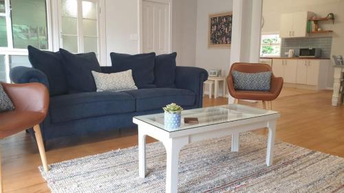 a living room with a blue couch and a coffee table at Walk From Wandal 