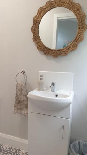 a bathroom with a sink and a mirror on the wall at Walk From Wandal 