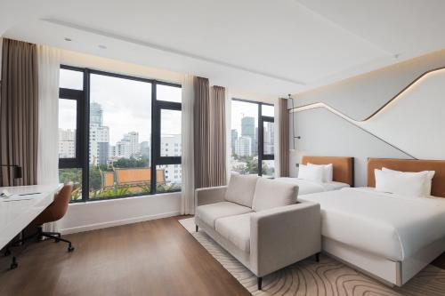 a hotel room with a bed and a desk at Bassac Signature Hotel & Residence in Phnom Penh