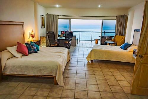 a hotel room with two beds and a view of the ocean at Oceanfront 4BR 20 PAX in Puerto Vallarta