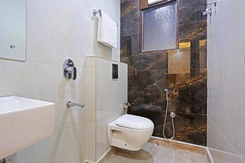 a bathroom with a toilet and a sink and a shower at Hotel Vijaydeep Place Near Delhi Airport in New Delhi