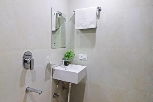 a white bathroom with a sink and a mirror at Hotel Vijaydeep Place Near Delhi Airport in New Delhi