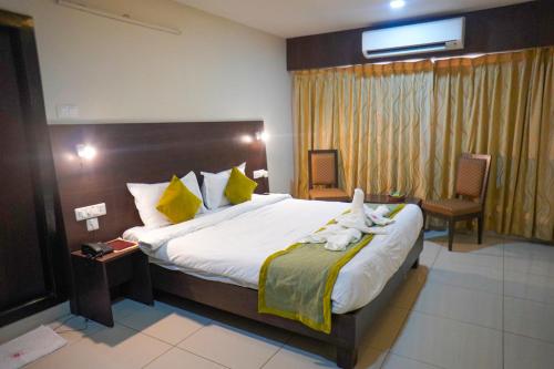 a bedroom with a large bed with towels on it at Hotel Green Park Elite in Kākināda