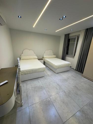 a room with two beds and a desk in it at The Royal Sea View Suite in Port Said