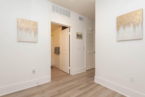 a room with white walls and paintings on the walls at The Modern Suite Residences in Glendale