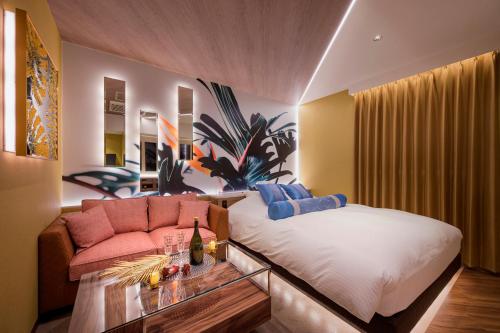 a bedroom with a bed and a couch at ホテルLuce Regaloｰルーチェレガーロ in Rifu