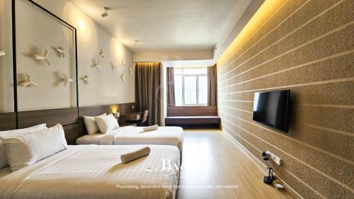 a hotel room with two beds and a flat screen tv at Windmill Upon Hills Serenity Retreat Genting in Genting Highlands