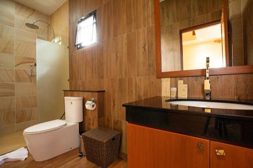 ein Badezimmer mit Toilette, Waschbecken und Spiegel in der Unterkunft Orchid Villa - 3 Bedrooms Pool Villa - Rawai beach in Rawai Beach