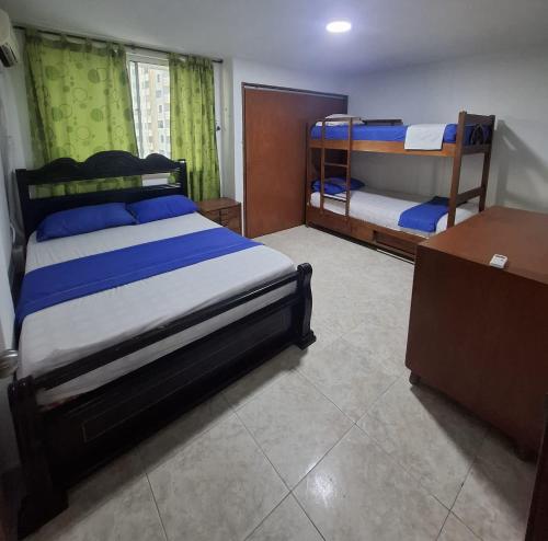a bedroom with two bunk beds and a desk at Apto Buritaca Piso 8 in Rodadero