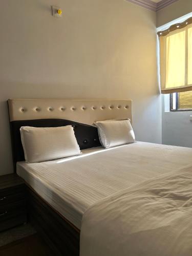 a bed with two pillows on it in a bedroom at Peepal Residency Budget Hotel in Bodhgaya in Bodh Gaya
