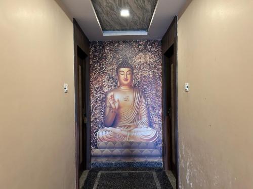 a mural of a buddha on a wall in a hallway at Peepal Residency Budget Hotel in Bodhgaya in Bodh Gaya