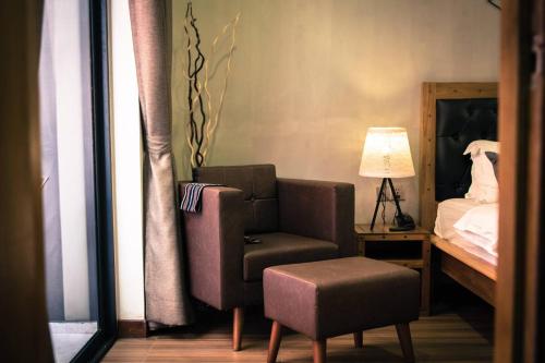 a bedroom with a chair and a bed with a lamp at Lavanya Boutique Hotel in Phnom Penh