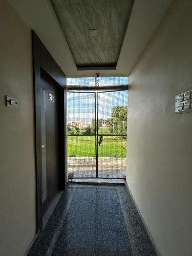 an empty hallway with a door leading to a window at Peepal Residency Budget Hotel in Bodhgaya in Bodh Gaya